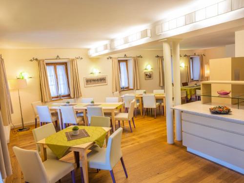 une salle à manger avec des tables et des chaises ainsi qu'une cuisine dans l'établissement Die Schmiede, à Ybbsitz