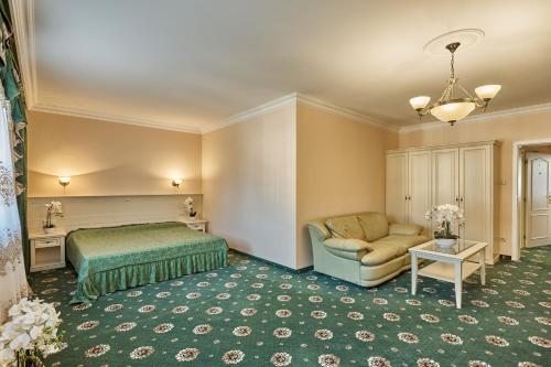 ein Hotelzimmer mit einem Bett und einer Couch in der Unterkunft Evergreen apartments hotel in Karlsbad