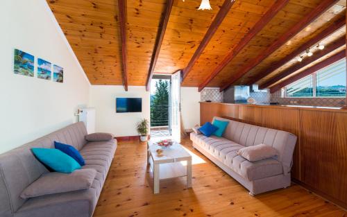 a living room with two couches and a table at Soso's Sea View Apartment in Plános
