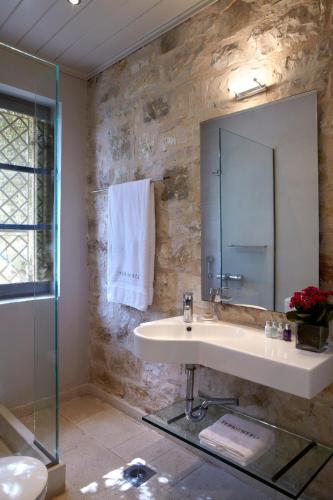 a bathroom with a sink and a mirror at Torri E Merli Boutique Hotel in Lákka