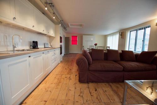 a living room with a couch and a kitchen at Spacious Apartment with Roof Terrace, near The Waterfront, Ipswich in Ipswich