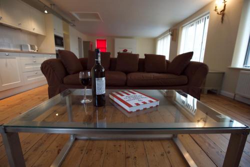 a living room with a glass table with a bottle of wine at Spacious Apartment with Roof Terrace, near The Waterfront, Ipswich in Ipswich