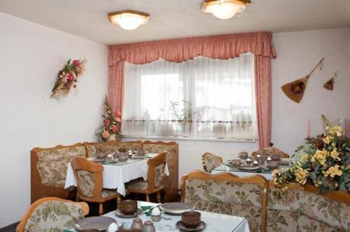 comedor con mesa, sillas y ventana en Pension "City" en Oschatz