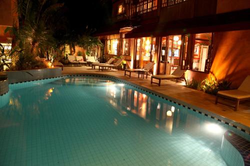 a large swimming pool in a hotel at night at Pousada Montão do Trigo Juquehy in Juquei