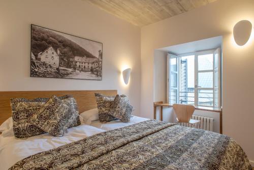 a bedroom with a large bed and a window at Hotel Roncesvalles in Roncesvalles