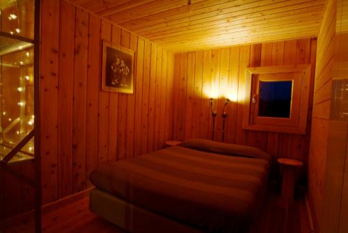 ein Schlafzimmer mit einem Bett in einem Holzzimmer in der Unterkunft Casa da Cerejeira - Casas de Alem - Ecoturismo in Arcos de Valdevez