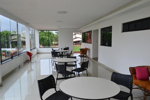 a room with tables and chairs and windows at Aldeia das Flores Hotel in Goiânia