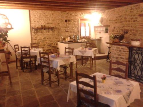 uma sala de jantar com mesas e cadeiras e uma cozinha em Alloggio Agrituristico Conte Ottelio em Pradamano