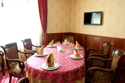 ein Esszimmer mit einem Tisch und einem roten Tischtuch in der Unterkunft Versal Hotel in Winnyzja