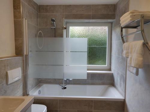 ein Bad mit einer Badewanne und einem Fenster in der Unterkunft Ferienwohnung Sonnenhang in Pfronten