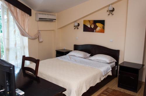 a bedroom with a bed and two tables and a window at Pensiunea Splendid in Dorohoi