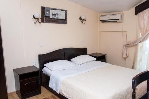 a bedroom with a large bed with two night stands at Pensiunea Splendid in Dorohoi