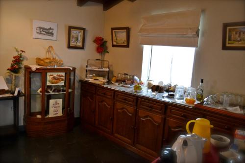 a kitchen with a counter top with a window at Quintal De Alem Do Ribeiro-Turismo Rural in Lousã