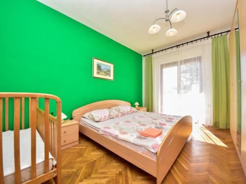 a green bedroom with a bed and a window at Apartment Lidija by Interhome in Vir