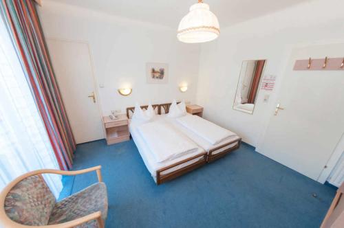 een hotelkamer met een bed en een stoel bij Hotel Goethehof in Bad Gastein