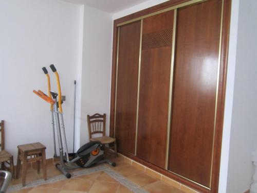 a large wooden closet in a room with a treadmill at Casa Mamica Rosario in Yegen