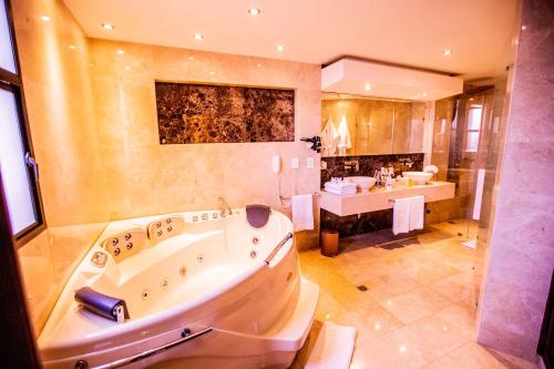 a large bathroom with a tub and a sink at Hotel Dann Carlton Cali in Cali