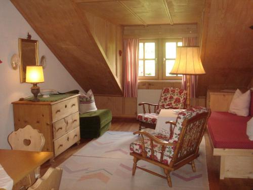 a living room with a bed and a chair and a dresser at Romantikhotel Almtalhof in Grünau im Almtal