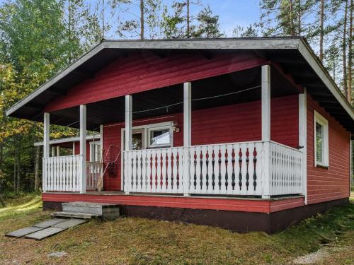 una casita roja diminuta con un porche blanco en Holiday Home Mäntylä by Interhome, en Nurmes