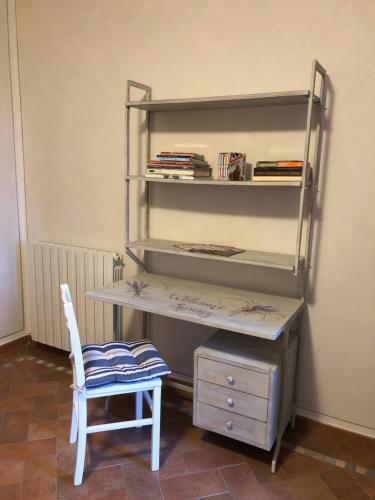 a desk with a chair next to a book shelf at Casa in campagna a due passi dal mare in Pisa