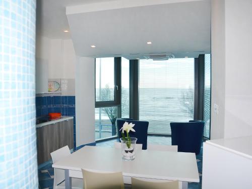 Un comedor con una mesa y sillas blancas. en Apartment Appartamento 2 by Interhome, en Porto Badino