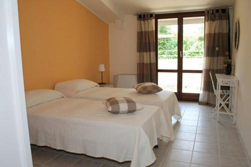 a bedroom with two beds and a window at Il Mulino Di Geminella in Narzole