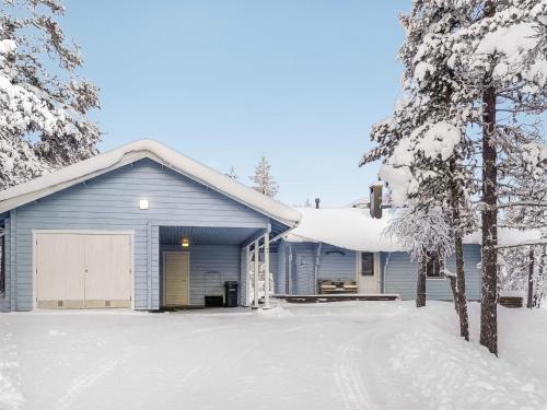 a house with a garage in the snow at Holiday Home Vuonelo by Interhome in Saariselka