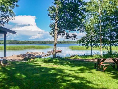 a picnic table and a dock on a lake at Holiday Home Långstrands stuga by Interhome in Långstrand