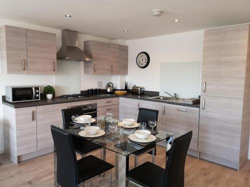 a kitchen with a black table and chairs in a kitchen at Mycosy At The Ocean in Aberdeen