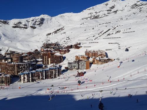 a snowy mountain with a town on a ski slope at Chalet L'Hermine in Val Thorens