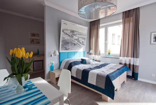 a blue and white bedroom with a bed and a table at Pokoje i Apartamenty Retro Gdynia in Gdynia