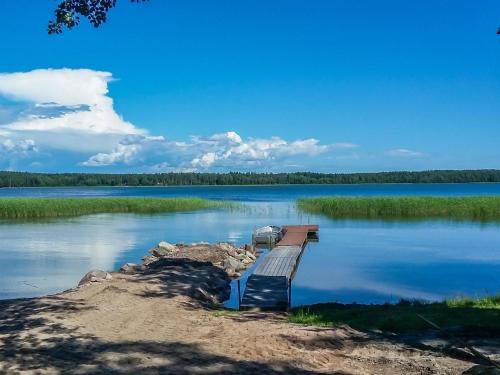 a bench on a dock on a lake at Holiday Home Långstrands stuga by Interhome in Långstrand