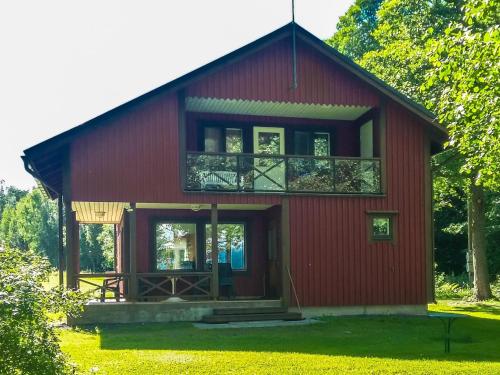 une maison rouge avec un balcon au-dessus dans l'établissement Holiday Home Långstrands stuga by Interhome, à Långstrand