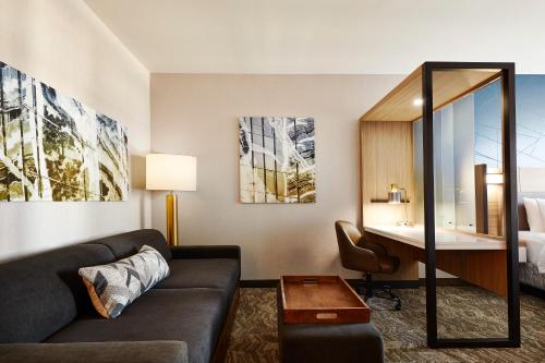 una sala de estar con sofá y escritorio en una habitación de hotel en SpringHill Suites by Marriott Springfield North, en Springfield
