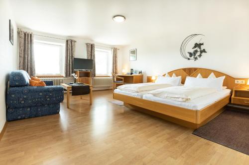 シュタイネンにあるHotel Landgasthof zum Pflugのベッドと椅子付きのホテルルーム