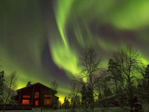 an image of the aurora borealis over a cabin at Holiday Home Aamunkoi by Interhome in Veskoniemi