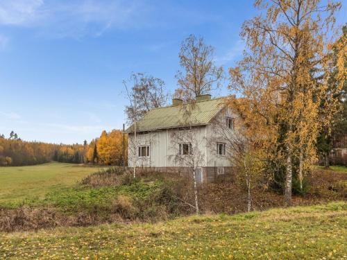 ein altes Haus auf einem Feld mit Bäumen in der Unterkunft Holiday Home Lehtoniemi by Interhome in Tallnäs