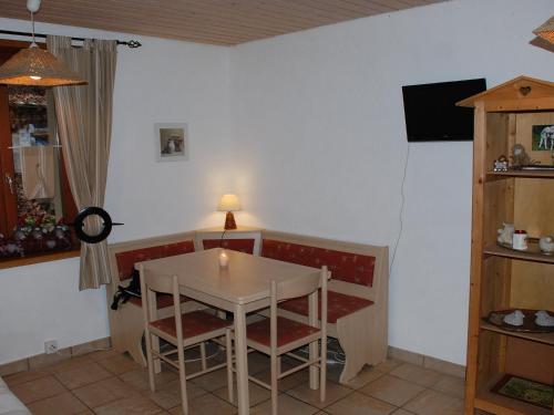 ein Esszimmer mit einem Tisch, Stühlen und einem TV in der Unterkunft Studio La Bergerie by Interhome in Ocourt