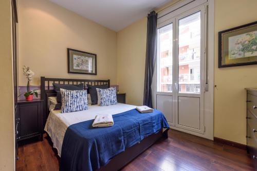 A bed or beds in a room at RamblasRentals Design Renovated Apartment AC Balcony10m Ramblas - Parking - Wifi