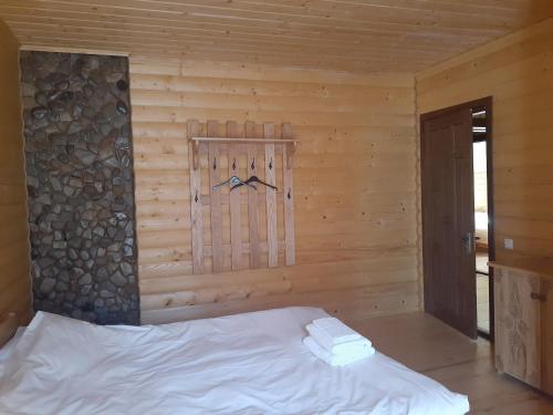 a bedroom with a bed in a wooden cabin at Біла хата in Iltsi