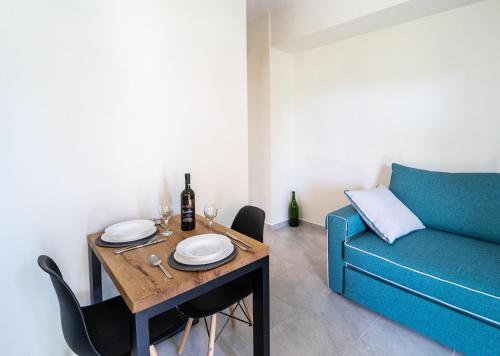 a dining room with a table and a blue couch at Apartments Katerina by the sea in Sami