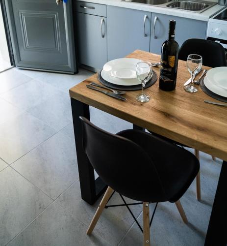 a wooden table with a bottle of wine and glasses at Apartments Katerina by the sea in Sami