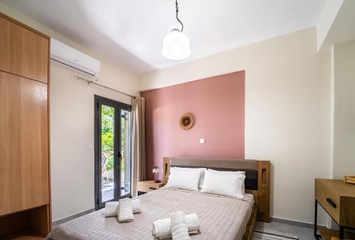 1 dormitorio con 2 camas y pared de color rosa en Apartments Katerina by the sea en Sami