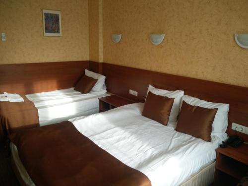 a hotel room with two beds and two tables at Slavyanska Beseda Hotel in Sofia
