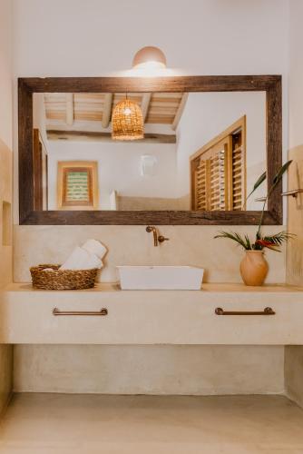 a bathroom with a sink and a mirror at Casa Pitanga - Caraíva in Caraíva