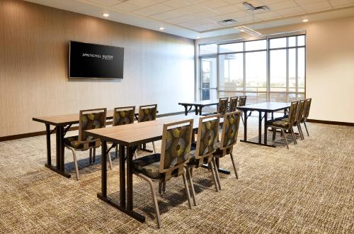 a conference room with tables and chairs and a flat screen tv at SpringHill Suites by Marriott Springfield North in Springfield