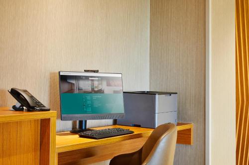 a desk with a computer and a phone on it at SpringHill Suites by Marriott Springfield North in Springfield