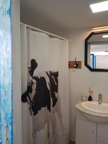 a bathroom with a black and white cow shower curtain at Sueño de Mar in Güimar