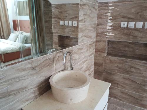 a bathroom with a sink and a mirror and a tub at Apartments & Pool Villa White House in Pančevo