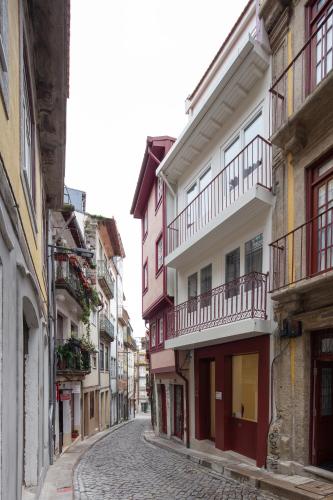 an alley in an old town with pink and white buildings at House of Artists in Porto